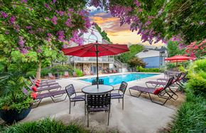 Hixson apartment for rent - a swimming pool with patio furniture and a red umbrella