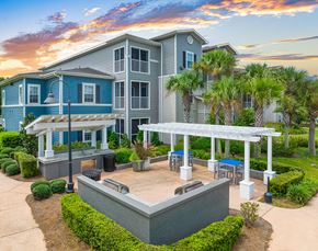 Gulf Shores apartment for rent - a large blue house with a patio with palm trees