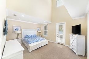 Orange Beach apartment for rent - A bedroom with a white bed, dresser, and nightstand.
