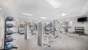 Cordova apartment for rent - a gym with weights and cardio equipment on the floor and a tv