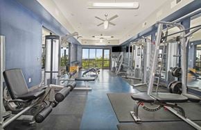 Kansas City apartment for rent - a gym with weights and cardio equipment and a window