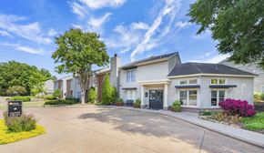 Memphis apartment for rent - the front of a white house with a driveway and trees