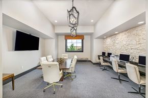 Overland Park apartment for rent - a conference room with desks and chairs and a tv on the wall