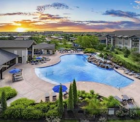 Overland Park apartment for rent - an aerial view of a resort style swimming pool at sunset
