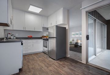 Danville apartment for rent - A modern kitchen with white cabinets and a wooden floor.