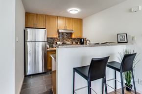 San Francisco apartment for rent - a kitchen with a bar with two stools and a refrigerator