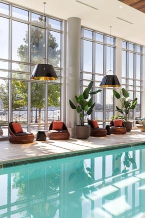 East Boston apartment for rent - a swimming pool with chairs and potted plants in front of a window