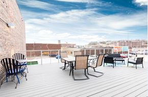 Sioux City apartment for rent - a rooftop patio with tables and chairs and a view of the city