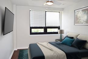 Wilmington apartment for rent - A bedroom with a bed, a window with blinds, a ceiling fan, and a painting on the wall.