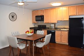 Wilmington apartment for rent - A kitchen with a table and chairs and a clock on the wall.