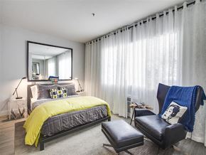 Los Angeles apartment for rent - a bedroom with a bed and a chair and a mirror