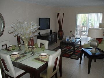 Miami apartment for rent - a living room with a dining table and a television