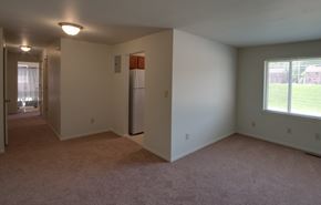 Baltimore apartment for rent - an empty living room with a large window and a refrigerator