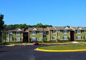 Hinesville apartment for rent - A red car is parked in the driveway of a green house.