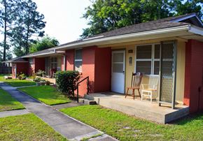 Hinesville apartment for rent - a porch with a rocking chair in front of a brick house