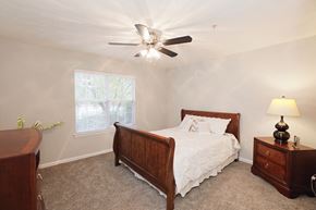 Lawrenceville apartment for rent - a bedroom with a bed and a ceiling fan