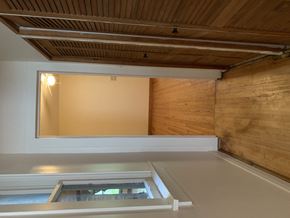 Chicago apartment for rent - a hallway with a closet and a window and a wooden floor