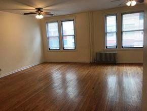 Chicago apartment for rent - an empty living room with wood floors and a ceiling fan