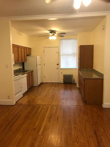 Chicago apartment for rent - an empty kitchen with wood floors and a ceiling fan