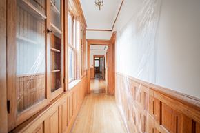 Chicago apartment for rent - a hallway with wood paneling and windows and a wooden floor
