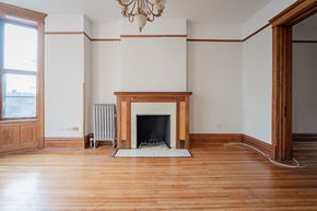 Chicago apartment for rent - an empty living room with a fireplace and wooden floors