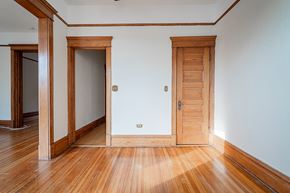 Chicago apartment for rent - a living room with wooden floors and a white wall and wooden doors