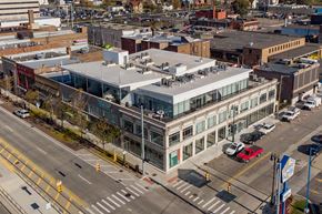 Detroit apartment for rent - A large building with a glass facade is situated in the middle of a busy intersection.