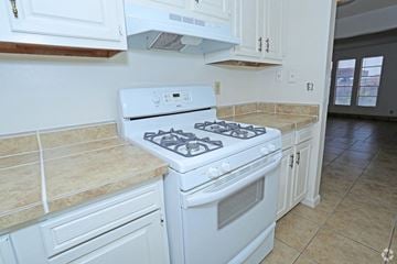 Las Vegas apartment for rent - A white gas stove in a kitchen with beige tiles.