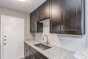Dallas apartment for rent - the kitchen of our studio apartment atrium with granite counter tops and dark cabinets
