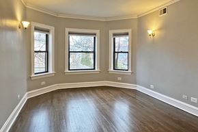 Oak Park apartment for rent - A room with wooden floors and three windows.
