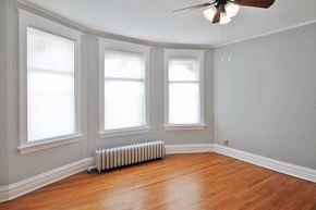 Oak Park apartment for rent - three windows in a room with wood floors and a ceiling fan