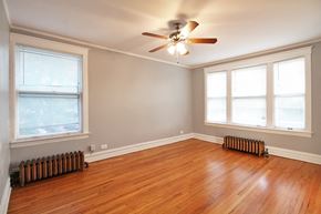 Oak Park apartment for rent - an empty living room with a ceiling fan and wood floors