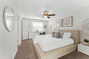 Casselberry townhouse for rent - A bedroom with a large bed and a ceiling fan.