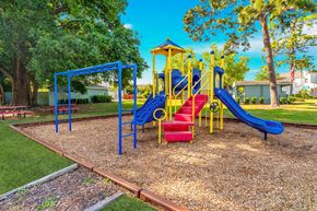 Casselberry townhouse for rent - A playground with a blue slide and red chairs.