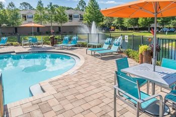 Pool deck with turquoise lounge chairs and umbrella