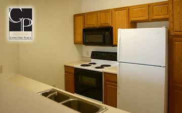 Oshkosh apartment for rent - a kitchen with white appliances and wooden cabinets