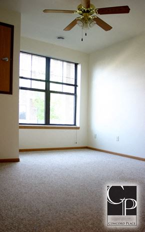 Oshkosh apartment for rent - an empty living room with a ceiling fan and a window