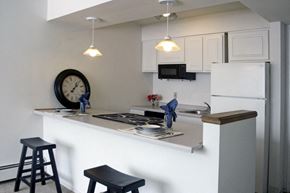 Oshkosh apartment for rent - a kitchen with white cabinets and a counter top and a clock