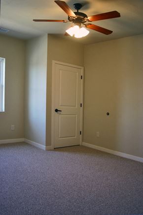 Oshkosh apartment for rent - an empty living room with a ceiling fan and a door