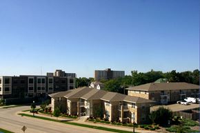 Oshkosh apartment for rent - a building with a street in front of it and some buildings