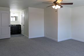De Pere apartment for rent - an empty living room with a ceiling fan and a kitchen
