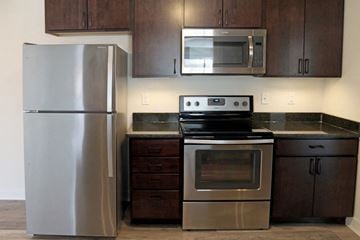De Pere apartment for rent - a kitchen with stainless steel appliances and wooden cabinets