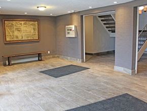 Parma Heights apartment for rent - building entry hall with a bench and a painting on the wall  at Valley York Apartments, Parma Heights, OH