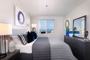 San Diego apartment for rent - A bedroom with a large bed and a view of the city.