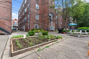 Philadelphia apartment for rent - a community garden in front of a brick building