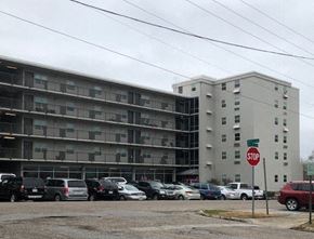 Meridian apartment for rent - a parking lot full of cars in front of an apartment building