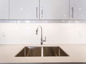 Mississauga apartment for rent - a stainless steel sink in a kitchen with white tiles