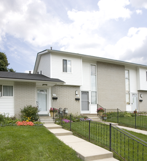 Pontiac townhouse for rent - a white house with a black fence in front of it