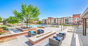 Westminster apartment for rent - A sunny day at a residential complex with a pool and lounge chairs.