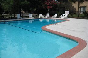 Charleston apartment for rent - a large blue swimming pool with white chairs